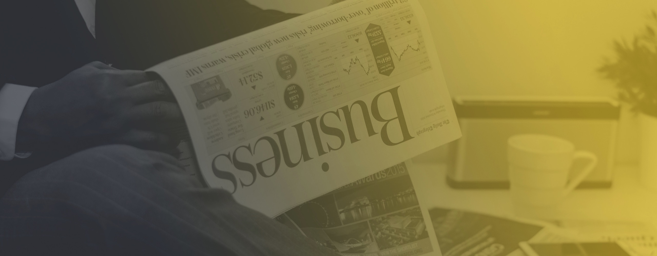 Image of man reading business pages of a newspaper